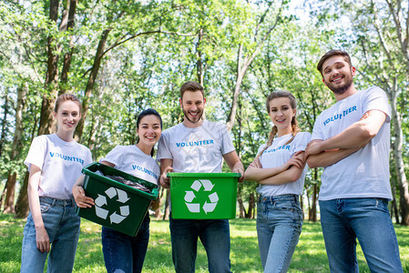 清扫公园后青年志愿者携带绿色回收箱图片