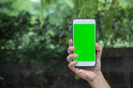 自然背景下带色度键绿屏的智能手机的智能人手图片