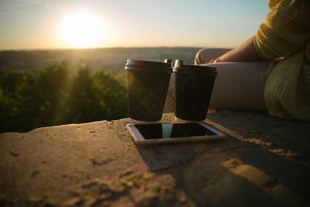 女人坐在山上喝着咖啡杯手图片