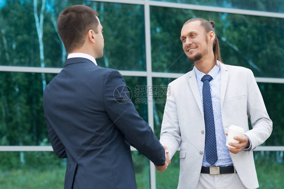生意人遇见他的搭档男人和另一个男人握图片