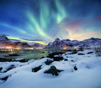 挪威罗弗敦群岛上的北极光山上的绿色北极光与极光的夜空夜间冬季景观与极光和水面上的反射挪设计图片