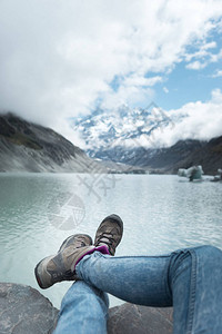 女在绿河山地和云天背景上行走图片