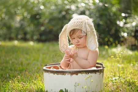 10个月大的女婴身着棕色被编织的兔子帽图片
