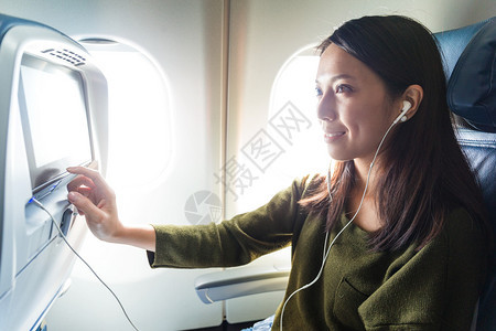 亚裔年轻女在飞机上看娱图片