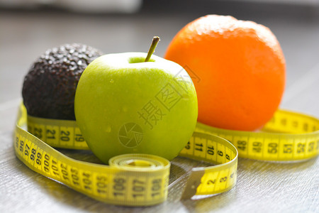 绿苹果橙子鳄梨和测量胶带以食背景图片
