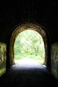 天光从一个老石头隧道里穿过自行车道从拱门入口进入白昼的图片