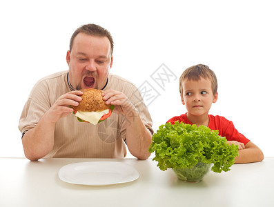 男人吃汉堡包男孩看沙拉健康饮食以实图片