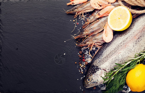 黑石背景上有香料的新鲜原始海鲜食品顶视图与复制空间图片