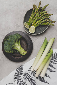 灰色板上和餐巾上新鲜健康绿色蔬图片