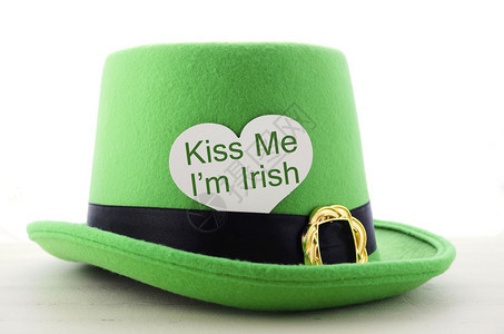 圣帕特里克节快乐绿色小妖精帽子在白木桌与亲吻我是爱尔兰心脏形图片
