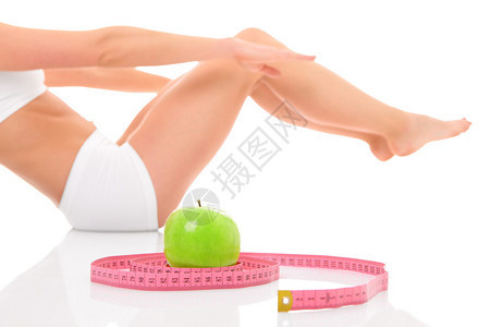 一张年轻健康女子在白色背景和苹果上运动的照片图片