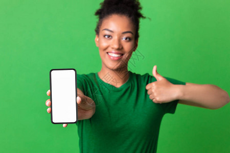 我喜欢这个手机千年非洲女孩用空白屏幕和拇指举起手势展示手机的图片