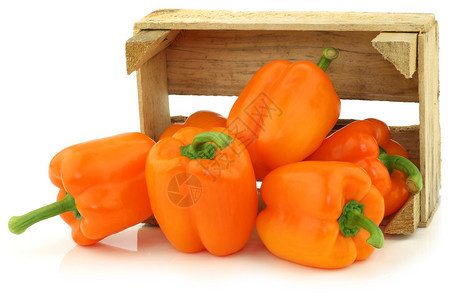 白色背景上木箱中的新鲜橙色甜椒图片