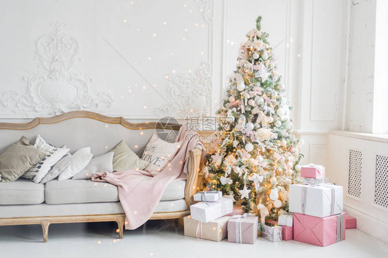 新年假期或庆祝活动心情时尚的圣诞简约内饰圣诞树下的礼物和包装礼物宽敞的白色客厅图片