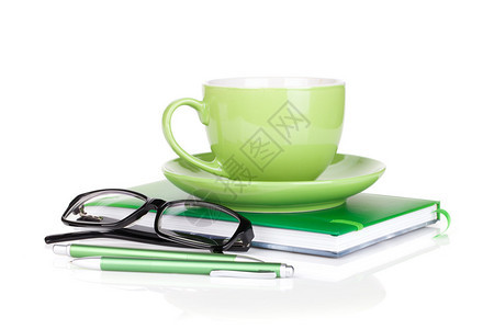 绿色咖啡杯眼镜和办公室用品白图片