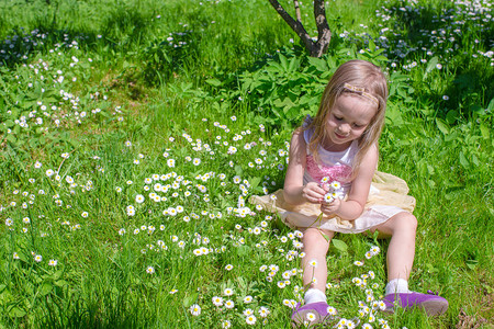 小女孩在林间空地采花背景图片