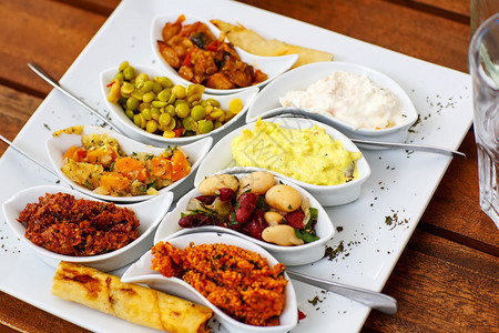 在咖啡馆或餐馆的白色餐盘上有不同的开胃图片