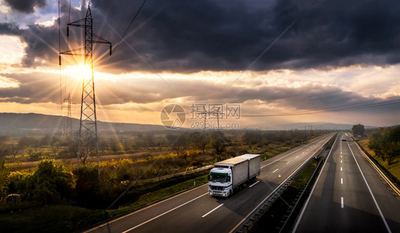 日落时有白色卡车的公路运输图片
