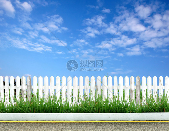 有绿草和蓝天的木篱芭图片