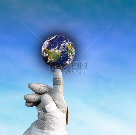 一位宇航员手握着地球的手在蓝天背景上图片