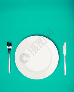 翡翠背景上的白色盘子叉子和刀子图片