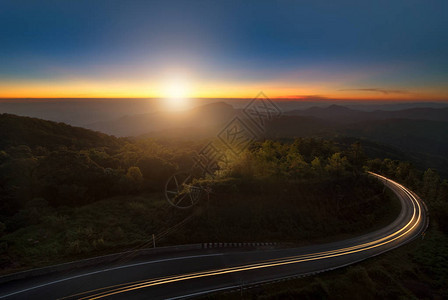 美丽的夕阳天空和云在山与雾和主要道路泰国清迈的茵图片