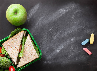 黑板上带蔬菜三明治和苹果的食品图片