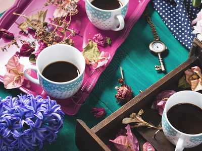 Espresso咖啡仍然有干燥新鲜粉红和紫色鲜花以绿色木图片