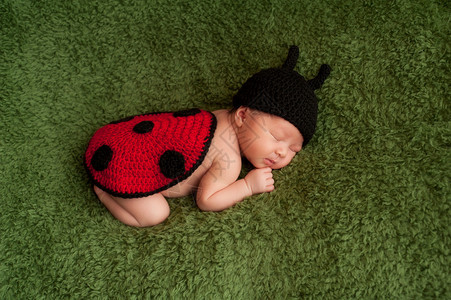 八天大的新生女孩穿着黑色和红色的编织花瓶装睡在图片