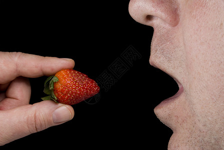 一个人吃着新鲜可口的草莓图片