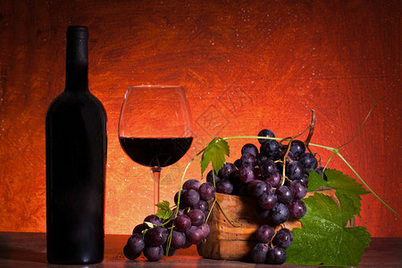红酒和葡萄在温暖的背图片