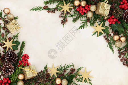 圣诞背景与古旧纸上的金黄装饰品霍利寄生虫纤维和雪松图片