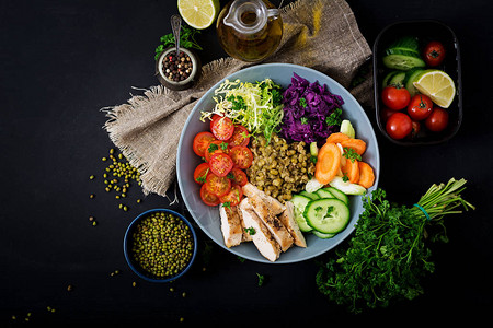 健康沙拉配鸡肉西红柿黄瓜生菜胡萝卜芹菜红卷心菜和绿豆在深色上适当的营养饮食菜单图片