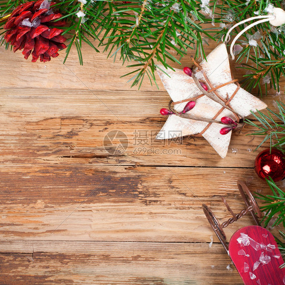 圣诞节背景与圣诞枞树星松果和雪橇在老式风格的旧木板上圣诞节概念与文图片