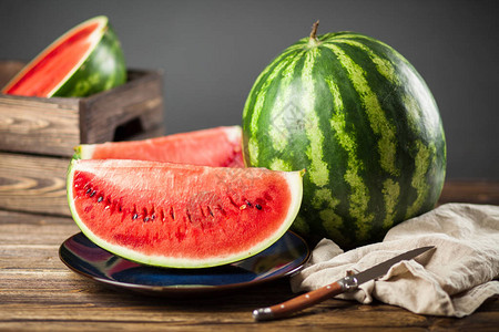 照片  |在木桌上切的各种有机瓜照片  |桌子上木盘子里的西瓜照片
