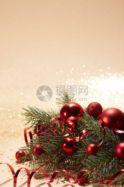 红色闪亮的圣诞玩具卷状丝带和松树枝图片