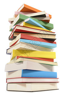 非常高的不整齐的堆叠或成堆在白色背景上隔绝的多彩书籍图片
