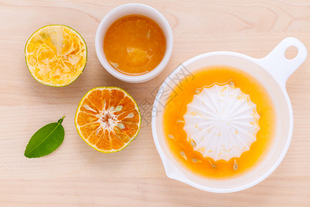 新鲜的橙汁和橙片放在木桌上图片