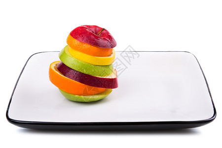 在白盘子里混合切片水果孤立图片