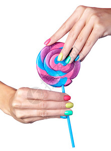 女人拿着棒糖带有亮绿色黄色粉红色和蓝色指甲的女手指修甲孤立在白色背景图片
