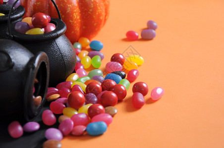 万圣节快乐的糖果在戏法或治疗中随身带着魔帽和橙色背景的果汁背景图片