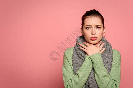 喉咙痛的生病女孩用被粉红色隔绝的温暖围巾包着的颈图片