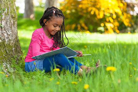 一位可爱的年轻黑人小女孩在读一本书图片