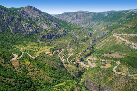 绿色山脉或岩石山谷与蜿蜒的道路景观在魔鬼桥附近的Vorotan河峡谷被阳光照亮了Tatev或TateviMetsAnapat的大图片