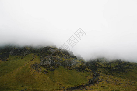 在雾中覆盖着青苔的雄伟岩石山丘冰岛图片
