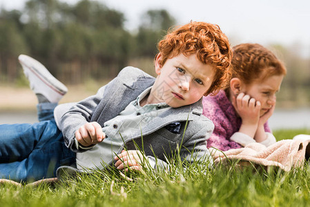 可爱的红发兄妹躺在草地上图片