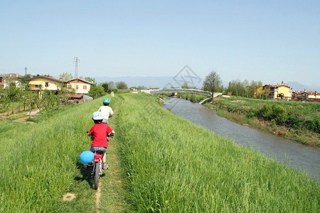 沿着河岸骑自行车的孩子们图片