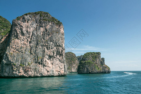 白岛覆盖绿色植物蓝天空和海洋的岩层石图片