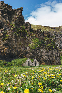 冰岛蓝云天空下山附近有青草屋顶的美丽居住房屋风景图片