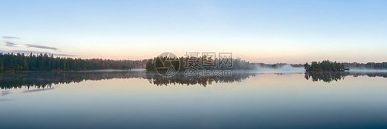 雾中湖上的晨景全景图片